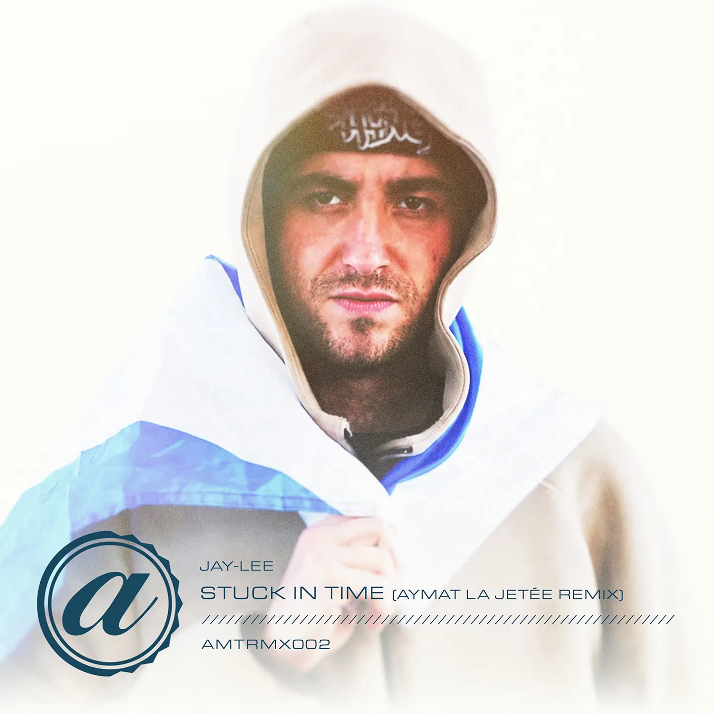 Digital album cover for the Jay-Lee "Stuck In Time" (Aymat La Jetée Remix) release, showing text and a stylized logo over a white backdrop with a close-up of a man in a hooded beige coat staring intensely at the camera, wrapped in a blue and white Scottish flag.
