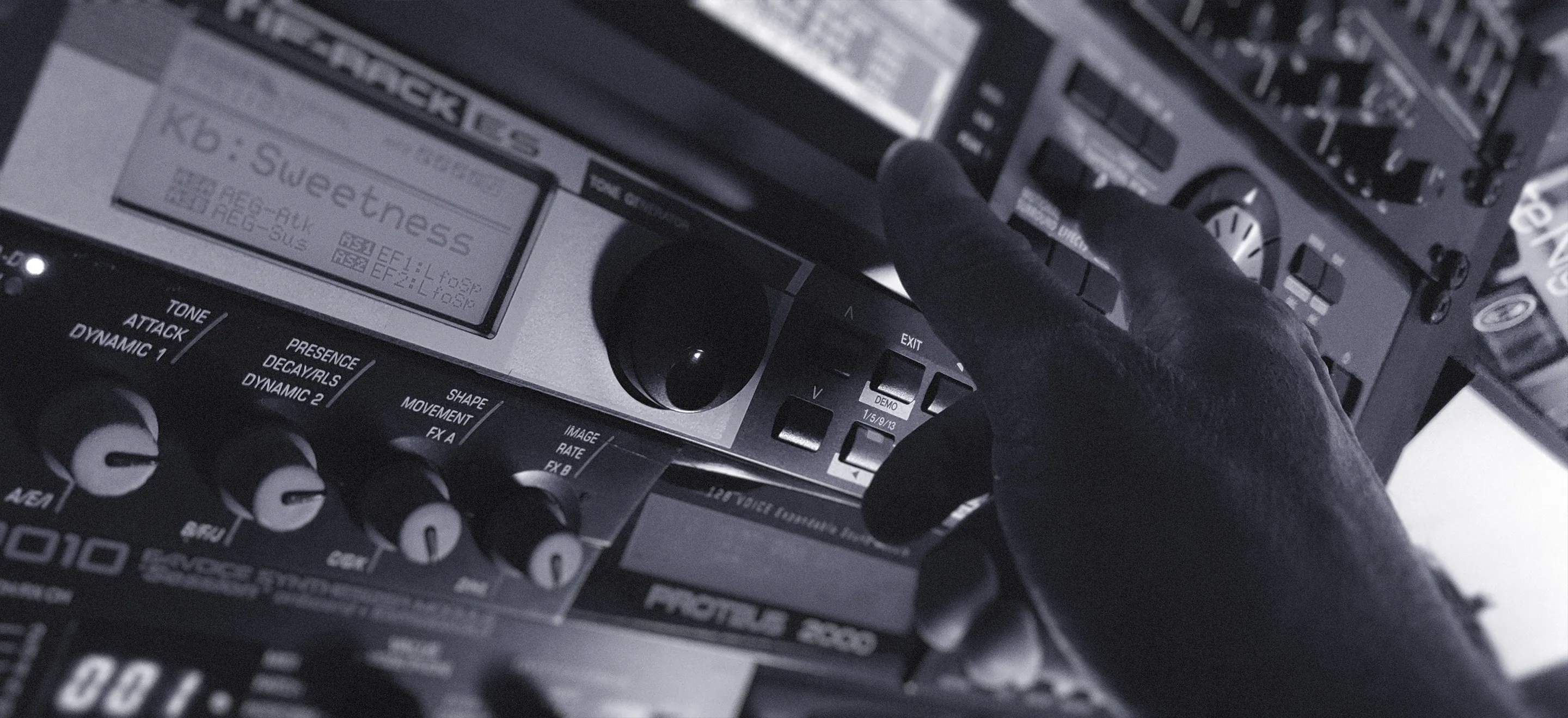 A person adjusting parameters on a synth rack module, showcasing a moment of engagement with the device.