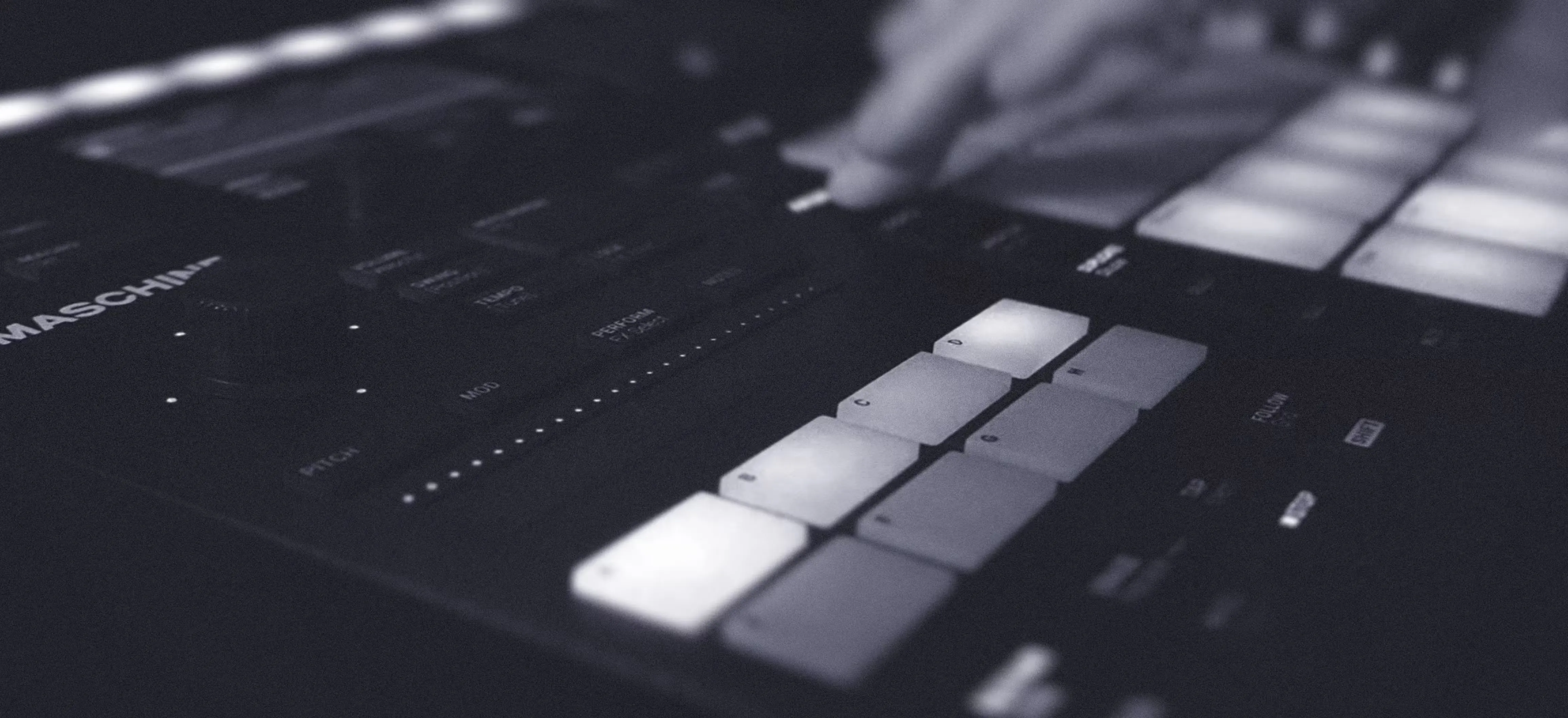A person interacts with a music controller, playing the keyboard and exploring music production.