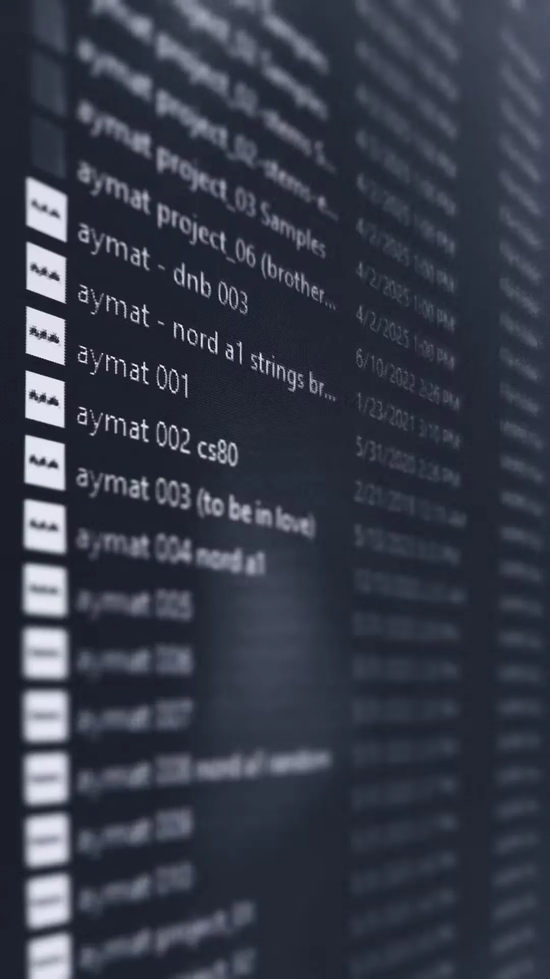 A computer screen displaying a list of audio files with names starting with "aymat" alongside dates and times. The background is blurred, creating a focused yet subdued tone.