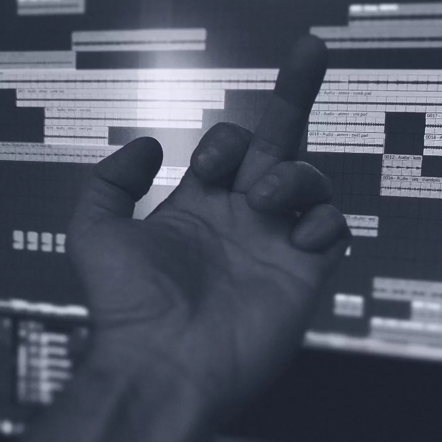 A hand is raised with the middle finger extended, silhouetted against a computer screen displaying an audio editing software interface, conveying frustration.
