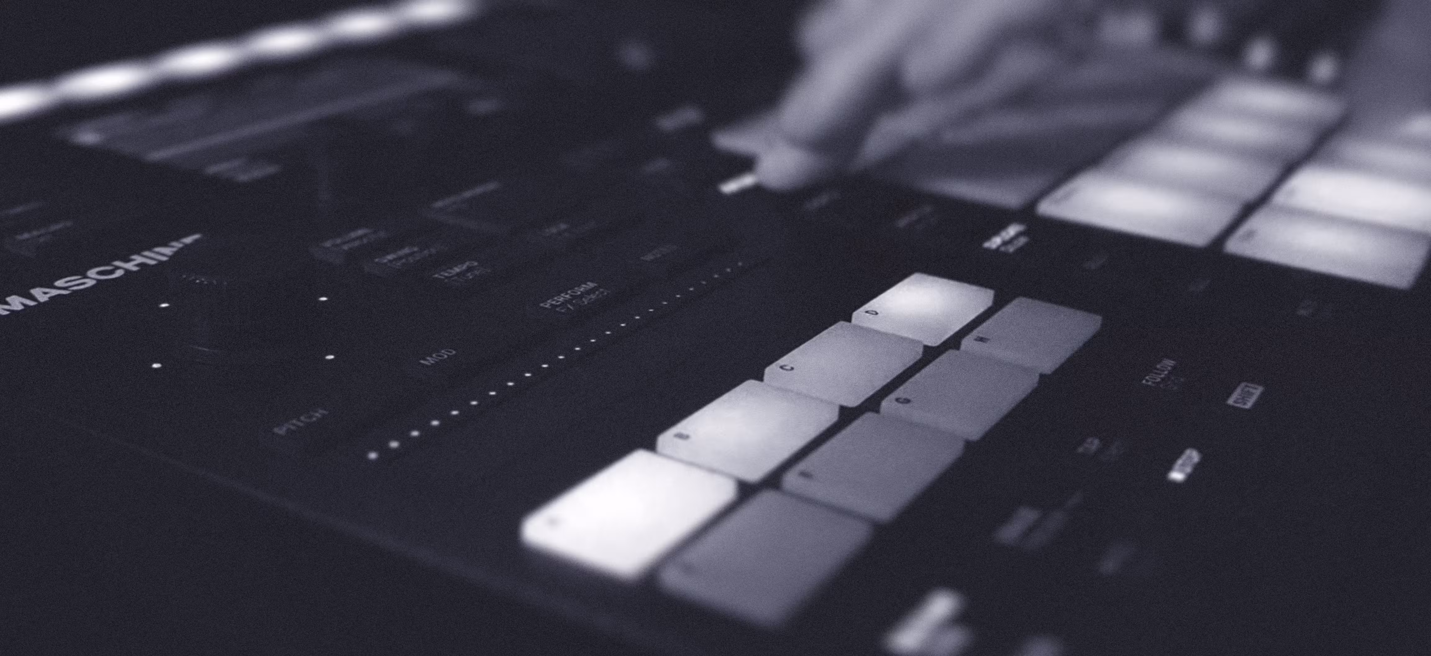 A person interacts with a music controller, playing the keyboard and exploring music production.