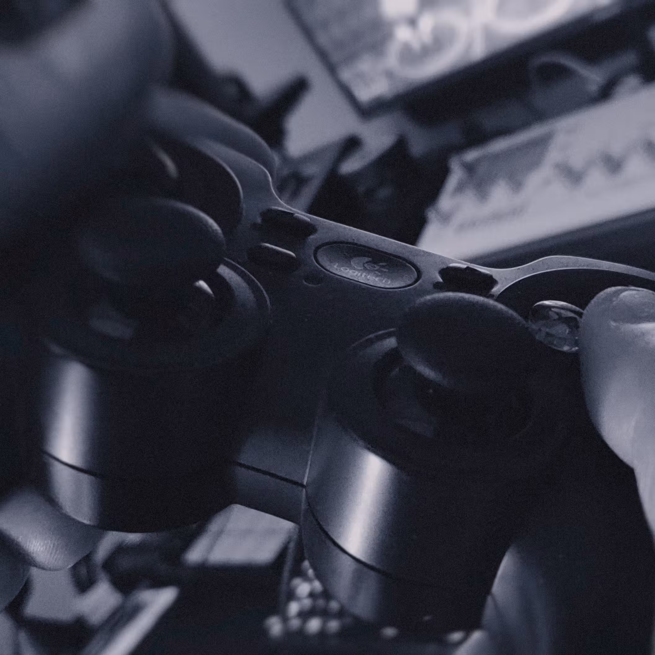 aymat-biggest-distraction-01 A close-up of hands holding a video game controller in front of a TV screen, with the image in black and white.